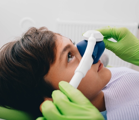 Young boy in dental chair wearing nose mask for nitrous oxide sedation dentistry