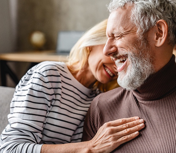 Happy older couple smiling with dentures