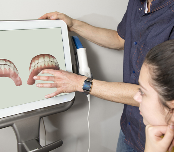 Dentist and patient looking at Clear Aligners digital treatment plan on computer