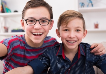Young boy with braces smiling with his brother